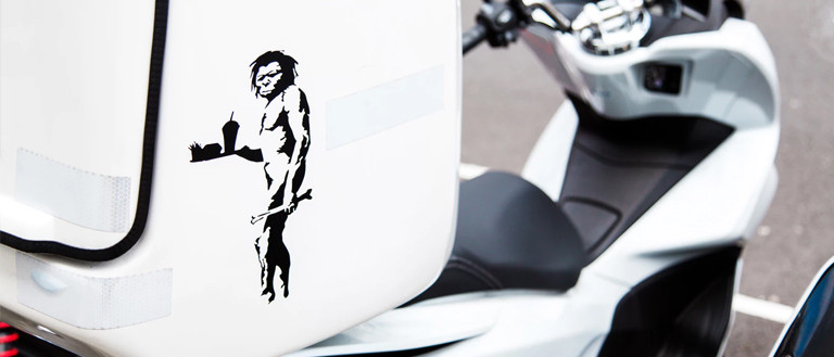 image of a caveman on a scooter